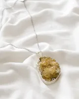 Collar con cadena de acero plateado y dije de piedra natural color amarillo con engarce plateado.