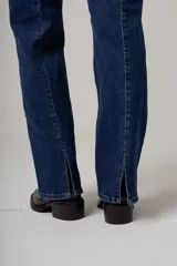 Jeans de denim color beige, de tiro alto y corte recto, con costuras verticales decorativas en el frente.
