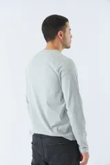 Remera negra de manga larga con cuello redondo abotonado y logo estampado en el pecho.