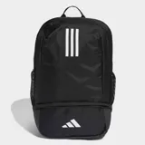 Mochila deportiva negra con tres franjas blancas verticales en el panel frontal y logo de Adidas Badge of Sport blanco en el bolsillo inferior. Posee un compartimento inferior con cierre para calzado y bolsillos laterales de malla.
