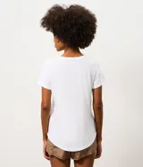 Remera deportiva de mujer Get Over, confeccionada en microfibra blanca con cuello redondo, manga corta y un diseño estampado de ondas en color verde y marrón en el lateral izquierdo.