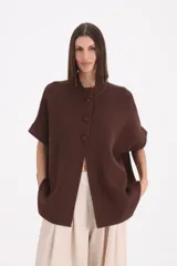 Saco de punto color chocolate, con cuello redondo, cierre frontal de tres botones y mangas cortas con dobladillo.