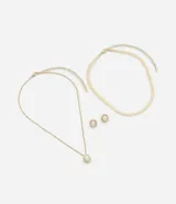 Conjunto de bisutería compuesto por un collar tipo cadena plana, un collar de cadena fina con dije de perla y un par de aros pequeños con perla aplicada. Presenta un acabado en tono dorado.