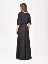 Vestido largo negro de corte evasé, con escote en V cruzado y mangas tres cuartos acampanadas.
