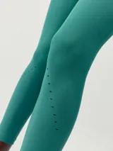 Legging deportivo largo 7/8 color verde azulado, tejido Fit_Tech con textura acanalada y micro calados decorativos en la parte inferior de la pierna. Presenta tiro alto y ajuste en glúteos.