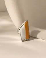 Anillo de diseño artesanal con piedra natural spóndylus bicolor en tonos blanco y naranja, engastada en una estructura minimalista de plata esterlina.