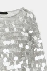 Vestido corto de punto con cuello redondo y manga larga, completamente cubierto de lentejuelas brillantes y perlas decorativas.
