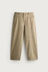 Pantalón relaxed fit de color beige, confeccionado en tejido con mezcla de algodón y lino, con diseño de cinco bolsillos, efecto lavado y cierre frontal con cremallera y botón.