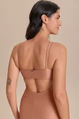 Jumpsuit corto de diseño ajustado con escote cuadrado y breteles finos. Confeccionado en tejido técnico con acabado ligeramente brillante y textura acanalada, ofrece compresión media y alta elasticidad.