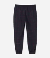 Pantalón de pijama tipo jogger para hombre, confeccionado en tejido plush suave y abrigado. Presenta un diseño estampado a cuadros, cintura elástica con cordón de ajuste y puños elásticos en los tobillos.