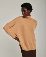 Sweater tipo poncho color beige, de mangas largas con sisa caída y cuello alto.