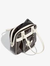 Bolso tipo shopper de Adidas, confeccionado en material sintético con acabado de charol brillante en color marrón oscuro y detalles en blanco. Presenta el logo del Trifolio estampado en el frente, bolsillo exterior con cierre y asas largas para llevar al hombro.