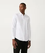 Camisa blanca de algodón, corte slim fit, manga larga y cuello clásico.