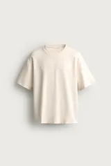 Remera de corte relaxed fit, color beige, confeccionada en tejido suave con mezcla de modal, de cuello redondo y manga corta.