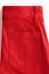 Pantalón en lona de algodón con cintura de tiro alto y cierre con botones. Piernas rectas con raya adelante y atrás, y bolsillos atrás de parche.