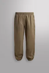 Pantalón jogger de corte regular confeccionado en tejido técnico ligero, con cintura elástica, bolsillos laterales con cierre y puños elásticos en los tobillos.