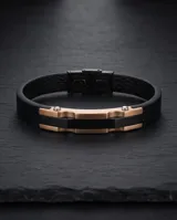 Pulsera masculina con diseño de placa central en acero con baño de oro rosa y detalles en negro, montada sobre una correa de cuerina negra con textura.