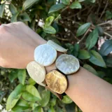 Pulsera elástica hecha de resina con círculos de color verde oliva y verde agua.