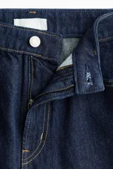 Jean wide leg de tiro alto en denim de algodón rígido color azul oscuro con costuras en contraste de color ocre. Cuenta con diseño de cinco bolsillos y cierre frontal con botón y cremallera.