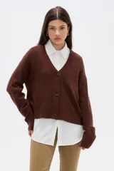 Cardigan de punto color marrón, con cuello en V profundo, cierre frontal con botones y diseño holgado de manga larga.