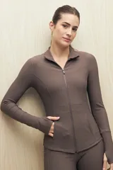 Campera deportiva de textura acanalada, color negro, con cierre frontal, cuello alto y mangas largas con orificio para el pulgar.