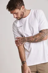 Remera blanca de manga corta y corte clásico, con estampa tipográfica minimalista en el pecho.