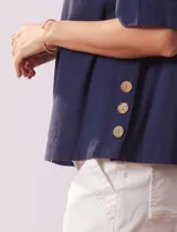 Blusa de algodón azul marino, de manga corta amplia, con tajo en el ruedo lateral decorado con botones.