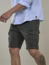 Bermuda cargo color marrón camel, confeccionada en twill con spandex, de calce cómodo y tiro medio. Cuenta con bolsillos laterales con solapa y bolsillos traseros con botón.