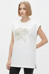 Remera negra de algodón, con cuello redondo, mangas cortas holgadas con vuelta y estampa floral grande en el pecho.