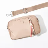 Bandolera rectangular color beige con correa ancha ajustable y desmontable. Incluye bolsillo frontal y adorno de cordones trenzados.
