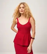 Blusa peplum de punto color rojo, sin mangas, con breteles anchos y escote redondeado.
