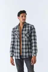 Sobrecamisa de algodón a cuadros color ladrillo, con interior de corderito, cierre con botones, bolsillos tipo cartera y logo en goma. El modelo usa talle M.