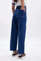 Pantalon de jean azul de corte ancho y tiro alto, con costuras a la vista y cierre frontal con boton y cremallera.