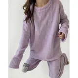 Conjunto de pijama de dos piezas confeccionado en tela de plush texturizada con diseño de rayas verticales en relieve. Incluye una remera de manga larga con cuello redondo y un pantalón de corte holgado. La remera presenta un pequeño bordado decorativo en el pecho.
