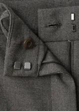 Pantalón gris de tiro medio, diseño recto y largo, con trabillas en la cintura y bolsillos laterales.