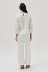 Blusa blanca de lino con mangas 3/4 con detalles de encaje.