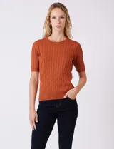 Buzo tejido marca Tahari, color verde, con cuello a la base, manga corta y diseño de ochos en el frente.