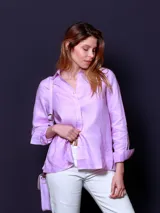 Camisa de manga larga color lila, con cuello camisero y cierre frontal de botones.