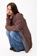Sweater de tejido artesanal con diseño de rayas verticales en tonos camel y beige, corte holgado, cuello redondo y puños altos ajustados.