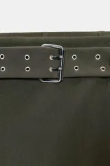 Falda pantalón de tiro medio color verde militar, con cinturón incorporado con hebilla metálica y ojales. Cierre lateral con cremallera oculta.