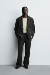 Blazer de corte regular fit con diseño de rayas diplomáticas. Presenta cuello con solapas de pico, cierre frontal de botonadura cruzada, mangas largas con botones en los puños, bolsillos de vivo en el pecho y bolsillos con solapa en la cadera.