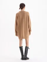 Sweater de punto color rojo con diseño de trenzas verticales y textura estructurada. Presenta cuello redondo, mangas largas y un corte holgado con terminaciones acanaladas.