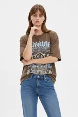 Remera de algodón color marfil, de corte holgado y mangas cortas, con cuello redondo y estampado frontal de diseño inspirado en la música con texto "The Endless County Keep On Rocking" y detalles de girasoles.