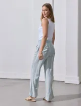 Pantalón de lino con pretina ancha en punto smock con lazo, bolsillos verticales delanteros y bolsillos aplicados traseros.