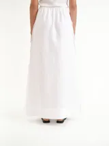 Pollera larga blanca de lino, con tajos laterales y diseño de tiro alto.