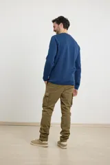 Pantalón cargo negro con bolsillos laterales con fuelle y corte recto.