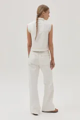 Pantalón de jean blanco, de calce recto y tiro medio-alto. Cuenta con un corte en la rodilla y ruedo desflecado.