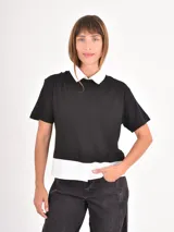 Remera de manga corta con diseño de doble capa, combinando una remera negra lisa con un cuello y ruedo de camisa blanca por debajo.