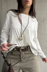 Remera blanca de manga larga con diseño holgado y escote bote. Cuenta con un delicado bordado floral en el hombro derecho.