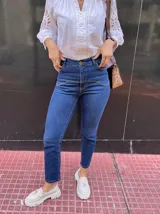 Pantalón de jean azul oscuro, corte recto, tiro alto y detalles de costuras en la parte superior.